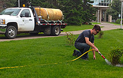 A groundskeeper at the U of S irrigating flower beds with collected rainwater